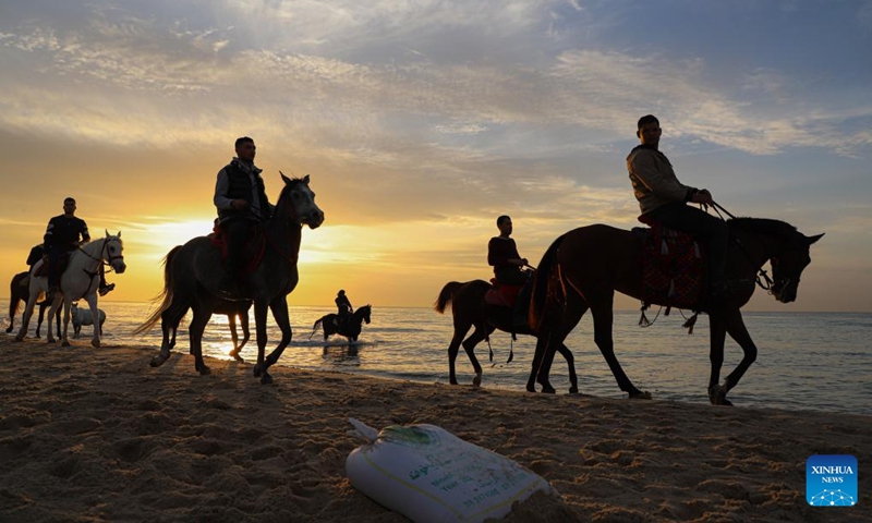 People ride horses at sunset on a beach of the Mediterranean Sea in Gaza City, on Jan. 27, 2023.(Photo: Xinhua)