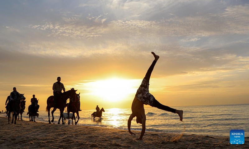 People have fun at sunset on a beach of the Mediterranean Sea in Gaza City, on Jan. 27, 2023.(Photo: Xinhua)