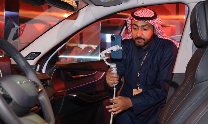 Photo taken on Jan. 28, 2023 shows a visitor taking photos in an EXEED car in a showcase in Riyadh, Saudi Arabia.(Photo: Xinhua)