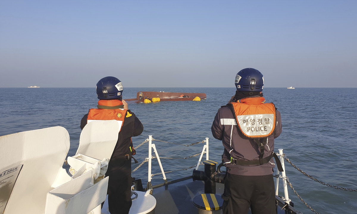 Members of South Korea's coast guard look at a capsized boat off the country's southwestern coast on February 5, 2023. South Korean coast guard vessels and aircraft have been carrying out a search for the nine fisherman who disappeared from the vessel after it capsized.  Photo: VCG 