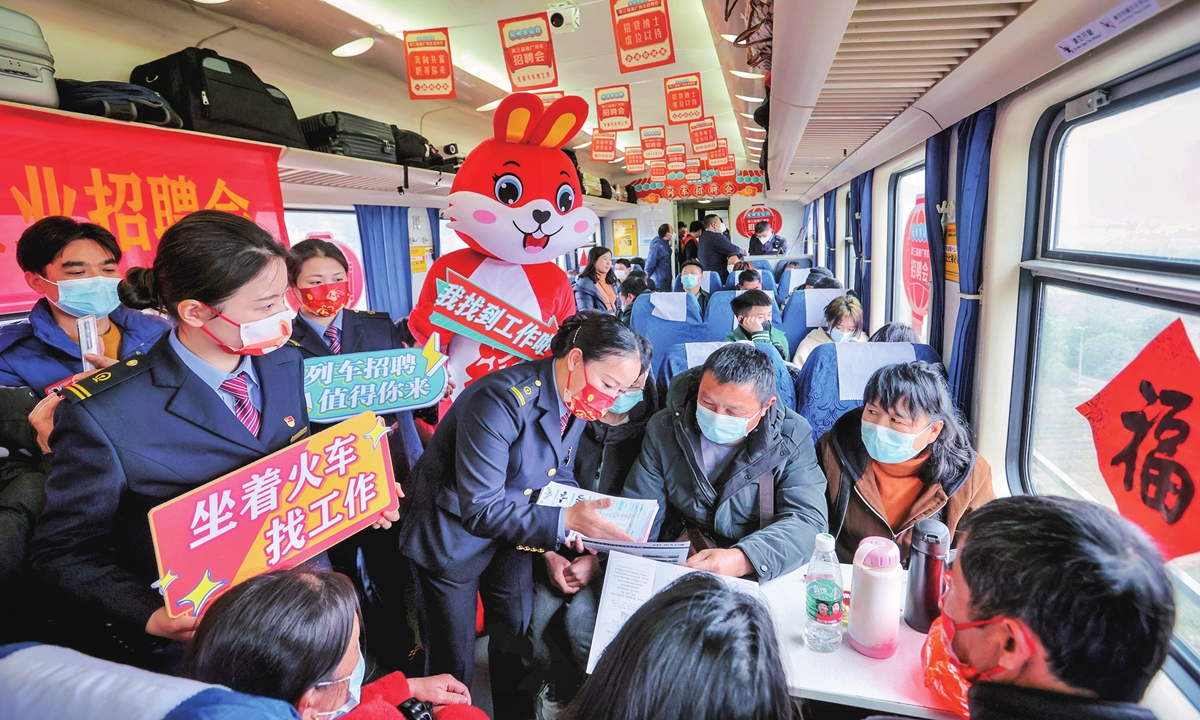 Train staffers hand out recruitment materials to passengers on a train from Guangzhou in South China's Guangdong Province to Ningbo in East China's Zhejiang Province on February 6, 2023. As many migrant workers returned to the region for work, the local train operator holds job fairs on the train to help them. Photo: cnsphoto