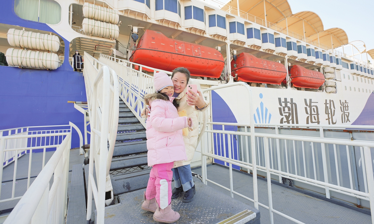 A mother and her daughter prepare to board the Bohai Mazhu passenger ship bound for Dalian, Northeast China's Liaoning Province, from Yantai, East China's Shandong Province on February 15, 2023, after the 40-day Spring Festival travel rush came to an end. Photo: IC