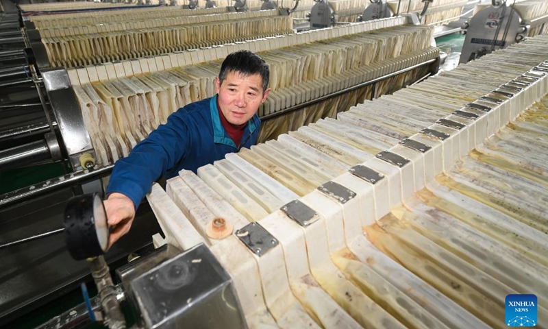 Winemaker Song Xinglei checks the feed pipe pressure at an extraction workshop of a rice wine brewery in Yuecheng District of Shaoxing, east China's Zhejiang Province, Feb. 7, 2023. Shaoxing is one of the largest production and sales bases of yellow rice wine in China. Shaoxing wine is still produced by locals nowadays with traditional method of brewing. The techniques of brewing Shaoxing rice wine was listed as a national intangible cultural heritage in 2006.(Photo: Xinhua)