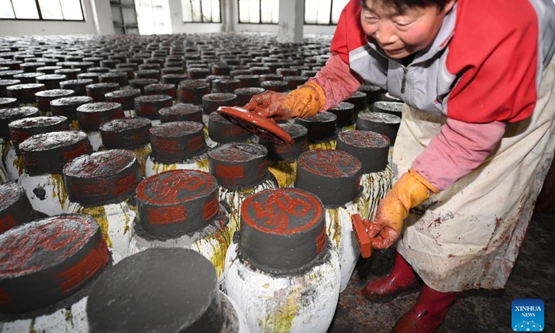 A worker seals wine crocks with mud at a rice wine brewery in Yuecheng District of Shaoxing, east China's Zhejiang Province, Feb. 7, 2023. Shaoxing is one of the largest production and sales bases of yellow rice wine in China. Shaoxing wine is still produced by locals nowadays with traditional method of brewing. The techniques of brewing Shaoxing rice wine was listed as a national intangible cultural heritage in 2006.(Photo: Xinhua)