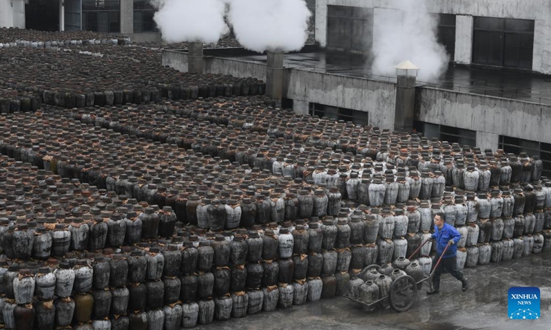 A worker transports crocks of wine at a rice wine brewery in Yuecheng District of Shaoxing, east China's Zhejiang Province, Feb. 7, 2023. Shaoxing is one of the largest production and sales bases of yellow rice wine in China. Shaoxing wine is still produced by locals nowadays with traditional method of brewing. The techniques of brewing Shaoxing rice wine was listed as a national intangible cultural heritage in 2006.(Photo: Xinhua)