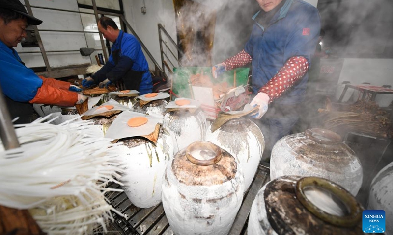 Workers seal wine crocks with lotus leaves and bamboo shells at a rice wine brewery in Yuecheng District of Shaoxing, east China's Zhejiang Province, Feb. 7, 2023. Shaoxing is one of the largest production and sales bases of yellow rice wine in China. Shaoxing wine is still produced by locals nowadays with traditional method of brewing. The techniques of brewing Shaoxing rice wine was listed as a national intangible cultural heritage in 2006.(Photo: Xinhua)