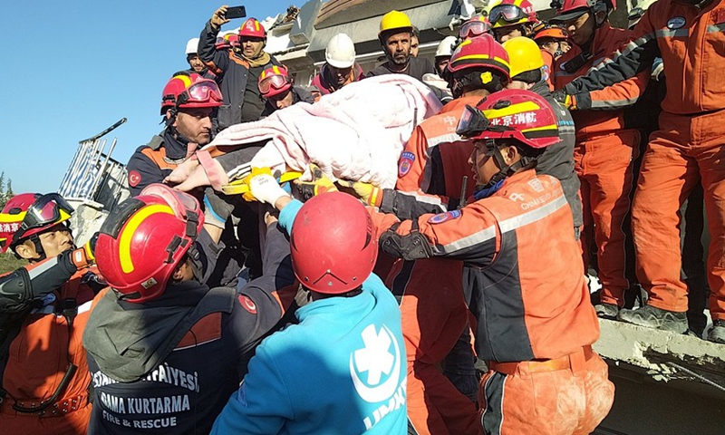 Members of the China Search and Rescue Team and Turkish rescuers join hands in pulling out a woman survivor from a collapsed building in Antakya in the southern province of Hatay, Türkiye, Feb. 9, 2023.(Photo: Xinhua)