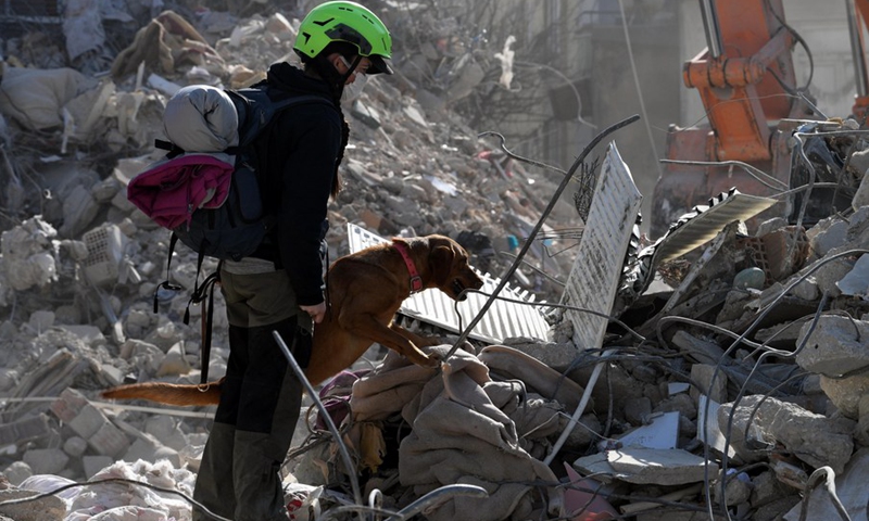 A woman and her dog search on earthquake debris in Antakya in the southern province of Hatay, Türkiye, Feb. 14, 2023(Photo: Xinhua)