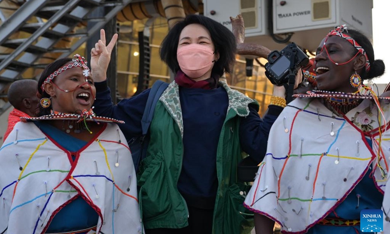 A Chinese tourist poses for a photo with Maasai performers at Jomo Kenyatta International Airport in Nairobi, Kenya, Feb. 11, 2023. A flight carrying 40 Chinese group tourists arrived at Jomo Kenyatta International Airport in Nairobi on Saturday. This is the first outbound tour group from China to Kenya since China resumed outbound group travel to 20 countries.(Photo: Xinhua)