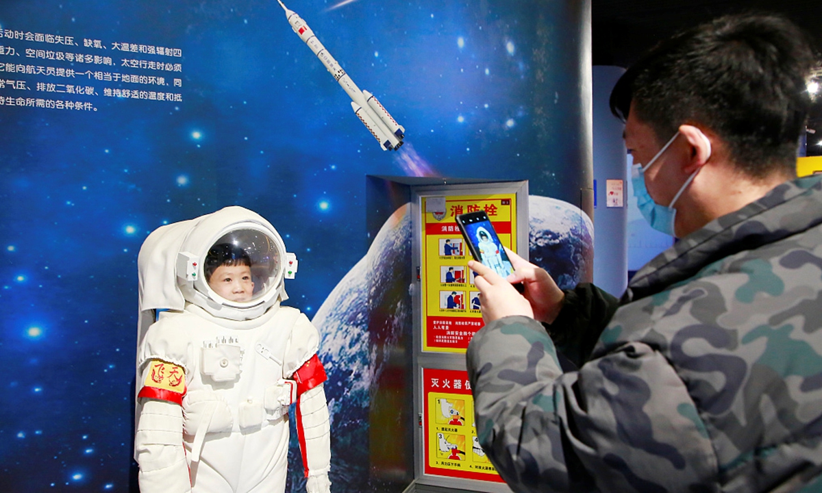 A father takes a photo of a child in an astronaut's suit at the Ningxia Science & Technology Museum in Yinchuan, Northwest China's Ningxia Hui Autonomous Region on February 19, 2023. The museum holds the special exhibition for local residents to learn about aerospace science and technology.  Photo: VCG