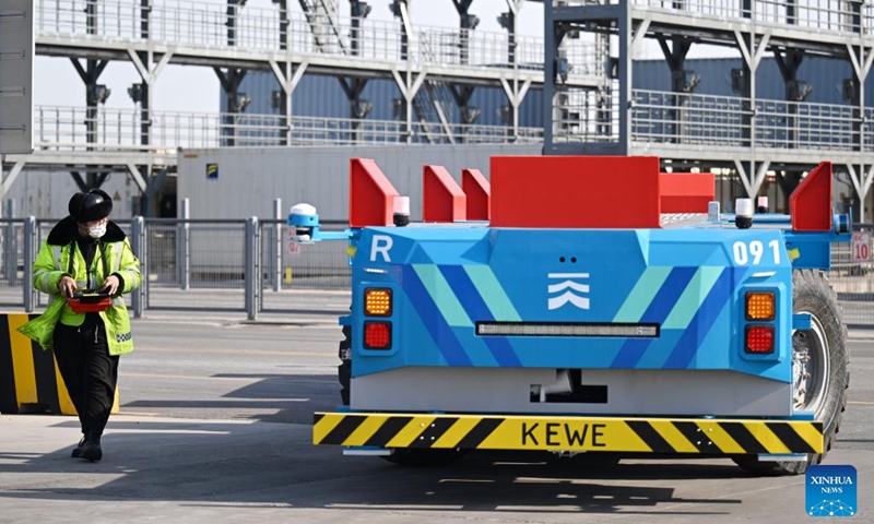 A staff member operates a smart delivery robot at the full Internet of Things container terminal of Tianjin Port in north China's Tianjin, Feb. 21, 2023. As the maritime gateway to the Beijing-Tianjin-Hebei region, Tianjin Port has been ceaselessly advancing the construction of a smart port, boosting the coordinated development of the region with fresh impetus.(Photo: Xinhua)