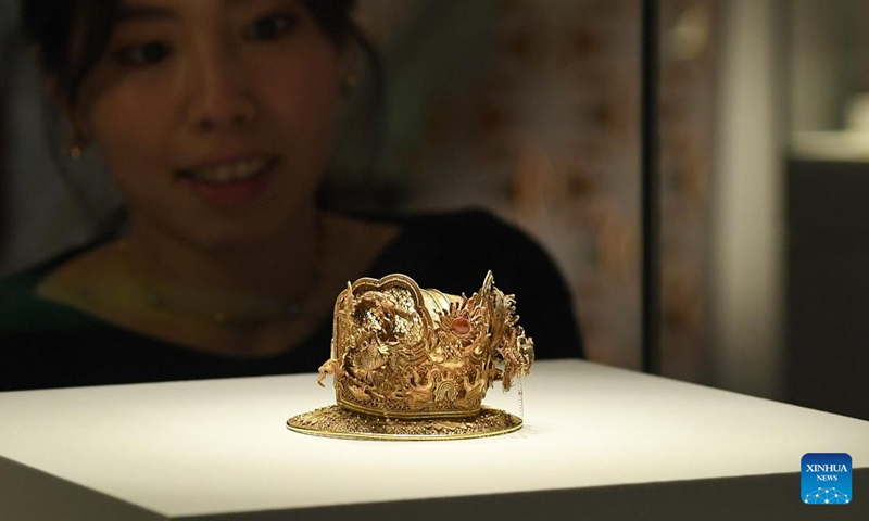 A journalist views an exhibit at the Hong Kong Palace Museum (HKPM) in south China's Hong Kong, Feb. 21, 2023. A special exhibition themed Radiance: Ancient Gold from the Hong Kong Palace Museum Collection and the Mengdiexuan Collection was unveiled here on Tuesday.(Photo: Xinhua)