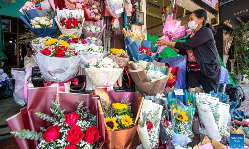 A vendor arranges flowers from southwest China's Yunnan province at the Pak Khlong Talat flower market in Bangkok, Thailand, Feb. 21, 2023. The deepening cooperation between Thailand and China under the Belt and Road Initiative (BRI) has benefited flower traders in both countries. Flowers grown and picked in southwest China's Yunnan Province can reach markets in Bangkok by cold chain transportation in about 40 hours.(Photo: Xinhua)