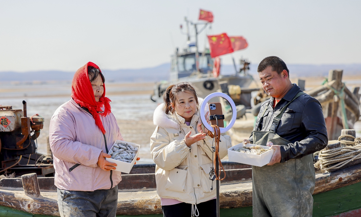 Livestreamers sell shrimps and other seafood by the shore in Qingdao, East China's Shandong Province on February 22, 2023. Through online platforms, potential customers can watch in real time as villagers and tourists rush to the sea to dig clams.Photo: VCG