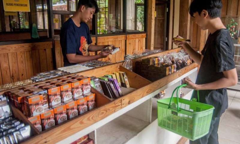 People buy cocoa products at Griya Cokelat Nglanggeran, a local chocolate production and souvenirs center in the village of Nglanggeran, in Gunung Kidul district, Yogyakarta, Indonesia, Feb. 25, 2023. (Photo by Agung Supriyanto/Xinhua)