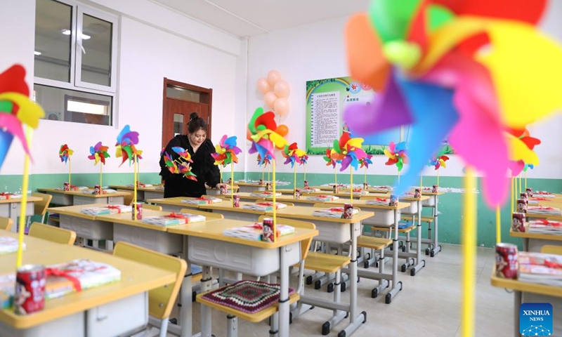 Teacher Lou Chongli decorates a classroom for the upcoming new semester at Yifu elementary school in Tai'an County, northeast China's Liaoning Province, Feb. 28, 2023. Primary and secondary schools in Liaoning will begin a new semester on March 1.(Photo: Xinhua)