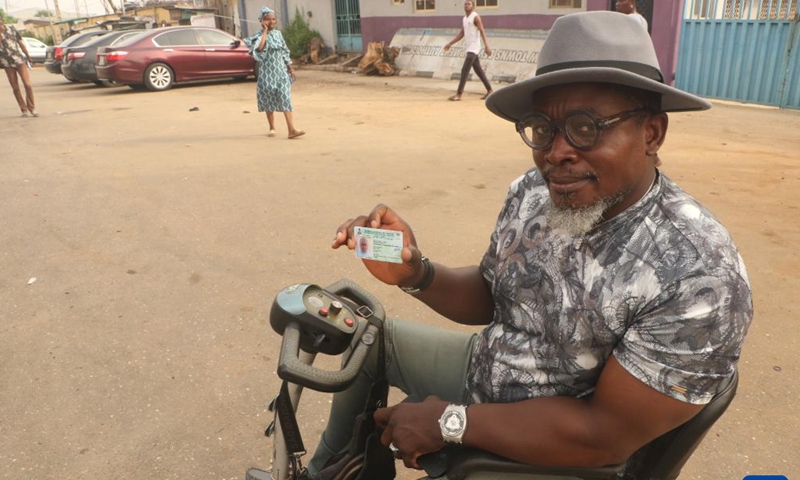 A man displays his voter's card at a polling station in Ikeja, Lagos state, Nigeria, on Feb. 25, 2023. Nigeria's presidential and parliamentary elections kicked off Saturday as voters went to the polls nationwide to elect a new president and members of the national assembly. (Photo by Emma Osodi/Xinhua)