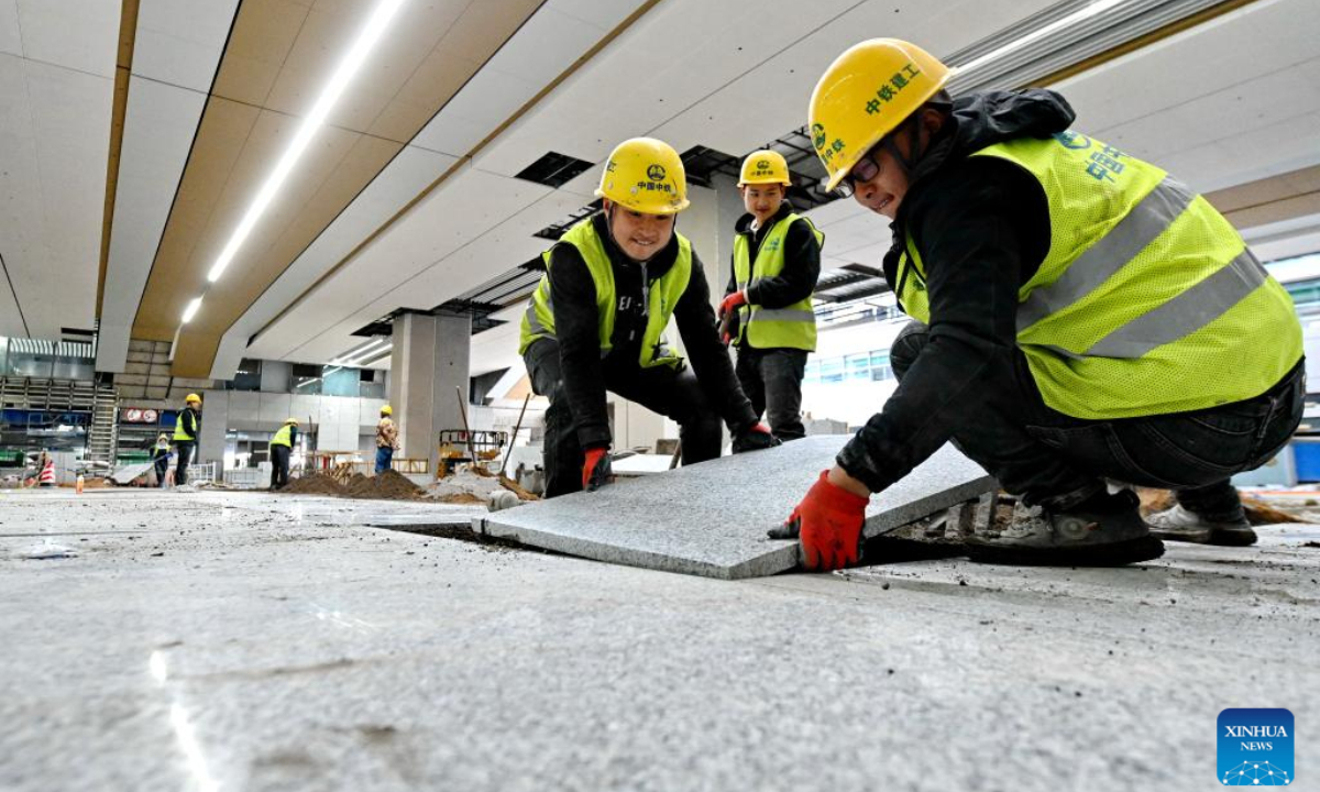 Constructors lay floor tiles at Fuzhou South Railway Station in Fuzhou, southeast China's Fujian Province, Feb 21, 2023.Photo:Xinhua