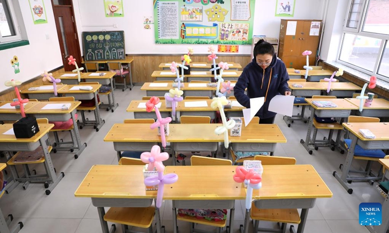 Teacher Yin Qi arranges teaching materials for the first class of the upcoming new semester at Yifu elementary school, in Tai'an County, northeast China's Liaoning Province, Feb. 28, 2023. Primary and secondary schools in Liaoning will begin a new semester on March 1.(Photo: Xinhua)