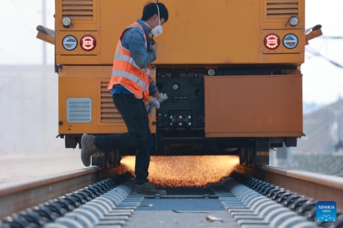 Working staff conduct rail track grinding work along rails near the Duyun East Railway Station along Guiyang-Nanning high-speed railway in Duyun, southwest China's Guizhou Province, Feb. 27, 2023. The Guiyang-Nanning high-speed railway, with a maximum speed of 350 km per hour, is expected to go into service in 2023.(Photo: Xinhua)