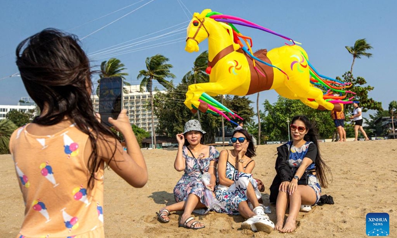 Tourists pose for photos with a kite at the beach in Pattaya, Thailand, Feb. 27, 2023. Kite enthusiasts and tourists gathered at Pattaya Beach to enjoy the international kite festival.(Photo: Xinhua)