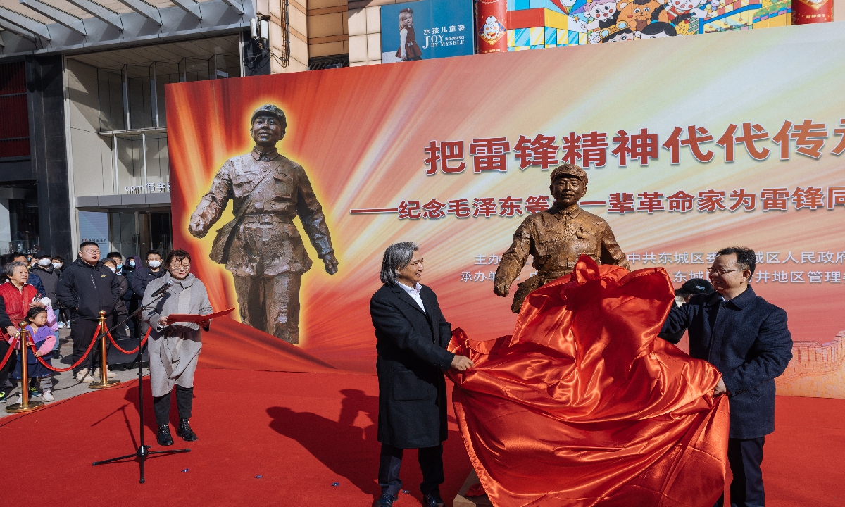 The statue of Chinese model soldier Lei Feng, by Chinese artist Wu Weishan (center), is unveiled on March 1, 2023 at Beijing's downtown Wangfujing Street to mark the 60th anniversary of the call to learn from Lei Feng by Mao Zedong and other older generation revolutionaries. The bronze statue was created in 2012 by Wu, president of National Art Museum of China. Photo: Li Hao/Global Times