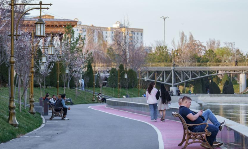 People enjoy an early spring day along a river in Tashkent, Uzbekistan, March 10, 2023. (Photo by Georgiy Namazov/Xinhua)