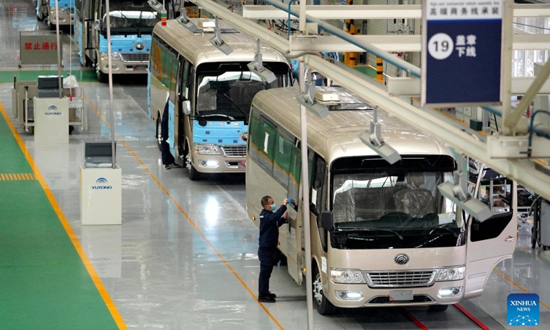 A staff member assembles the door of a bus at a work shop of the new energy factory of Zhengzhou Yutong Bus Co., Ltd. in Zhengzhou, central China's Henan Province, March 8, 2023. To catch orders, staff of the new energy factory of Yutong are busy on the assembly line. Since the beginning of this year, Yutong. who exported its bus to more than 30 countries and regions, has won many overseas orders.(Photo: Xinhua)