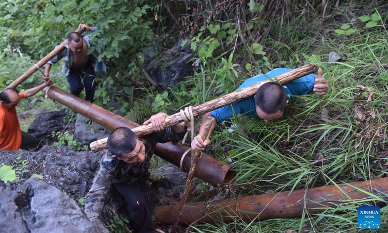 This photo taken on Aug. 18, 2016 shows villagers carrying water pipes on a mountain road in Nonglei Village of Bansheng Township, Dahua Yao Autonomous County, south China's Guangxi Zhuang Autonomous Region. Situated at the center of the Karst landforms in west Guangxi, Dahua Yao Autonomous County had suffered from severe water deficit for ages. (Photo: Xinhua)