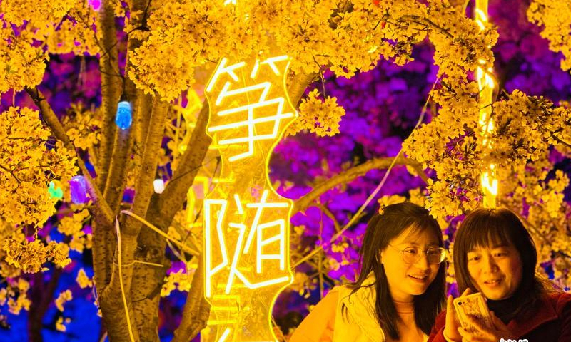 People are enchanted by cherry blossoms with colorful lights at night in Yantai, east China's Shandong Province, April 3, 2023. (Photo: China News Service/Qu Yuzhi)