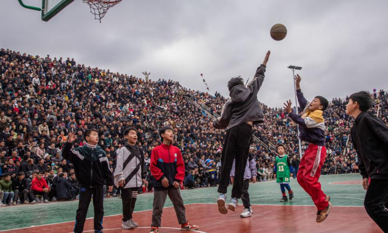 Kids play basketball in Taipan Village, Taijiang County, southwest China's Guizhou Province, March 25, 2023. Village Basketball Association or Village BA, is a grassroot basketball tournament held in Taipan Village. Organized by local residents, this event has gained popularity over the years and draws a large crowd of spectators and participants alike. The tournament showcases the passion and skills of basketball players from rural areas, as they compete and demonstrate their teamwork on the court. (Xinhua/Wu Zhuang)