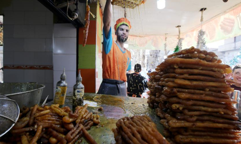 A man makes traditional dessert known as Zalabia during Ramadan in Boufarik, Algeria, on March 28, 2023. (Xinhua)