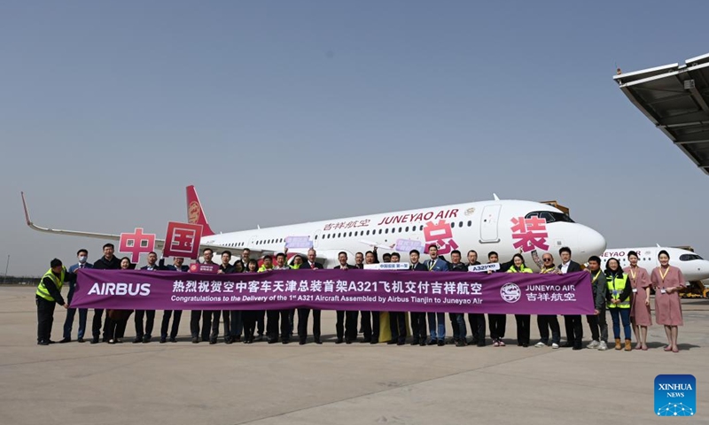 Staff members of European aircraft manufacturer Airbus and Shanghai-based Juneyao Air, who attend the delivery ceremony of the first China-assembled A321neo aircraft, pose for a group photo in front of the aircraft in north China's Tianjin on March 24, 2023. European aircraft manufacturer Airbus started delivering A321neo aircraft assembled at its Final Assembly Line Asia (FALA) facility in north China's Tianjin Friday. Photo: Xinhua