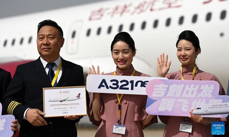 Crew members from Shanghai-based Juneyao Air, who attend the delivery ceremony of the first China-assembled A321neo aircraft, pose for a group photo in front of the aircraft in north China's Tianjin on March 24, 2023. European aircraft manufacturer Airbus started delivering A321neo aircraft assembled at its Final Assembly Line Asia (FALA) facility in north China's Tianjin Friday. Photo: Xinhua