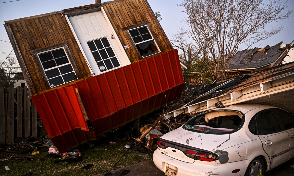 The remains of a crushed house and a car are seen in Rolling Fork, Mississippi, on March 25, 2023, after a tornado touched down in the area. As of press time, at least 26 people have been killed by devastating tornadoes that ripped across the southern US state of Mississippi, tearing off roofs, smashing cars and flattening entire neighborhoods. Photo: AFP