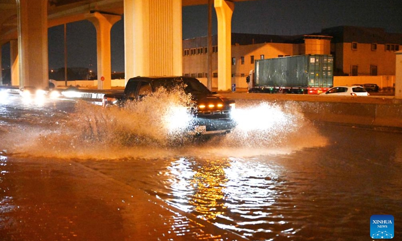 A vehicle drives on a flooded street in Capital Governorate, Kuwait, March 26, 2023. (Photo by Asad/Xinhua)