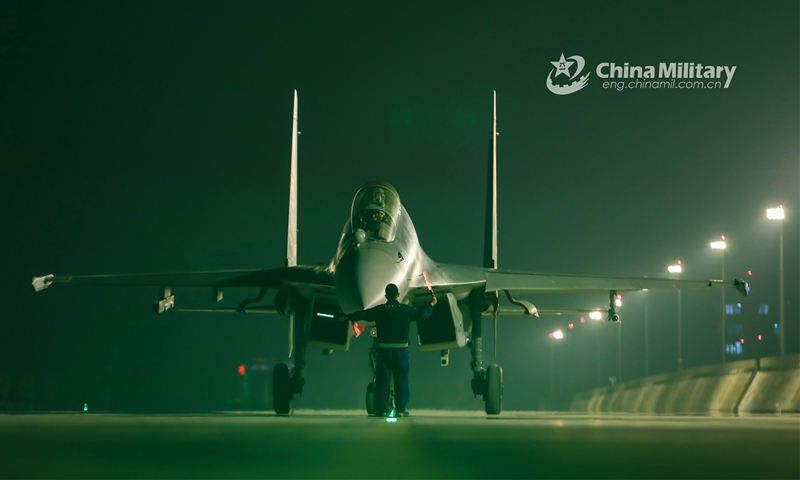 A ground crew member assigned to an aviation brigade of the air force under the PLA Southern Theater Command signals the pilot to taxi the fighter jet into the hangar during a day-and-night flight training exercise on March 11, 2023. (eng.chinamil.com.cn/Photo by Hao Hunan)