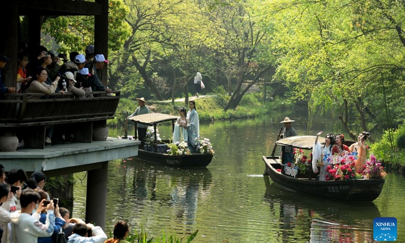 Tourists watch presentation of traditional Chinese clothing Hanfu in Xixi Wetland in Hangzhou, capital of east China's Zhejiang Province, April 2, 2023. Lovers of traditional Chinese clothing Hanfu gathered here for a flower fairies festival to celebrate the coming of spring.(Photo: Xinhua)