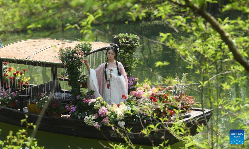 A young woman in traditional Chinese clothing Hanfu tours on a boat in Xixi Wetland in Hangzhou, capital of east China's Zhejiang Province, April 2, 2023. Lovers of traditional Chinese clothing Hanfu gathered here for a flower fairies festival to celebrate the coming of spring.(Photo: Xinhua)