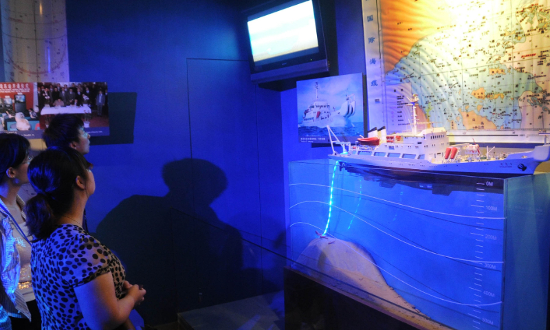 Visitors observe a simulation scene of undersea communication cable laying at Shanghai Telecom Museum on June 24, 2011. Photo: VCG