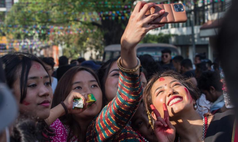 Newar girls in traditional attire take a selfie during a cultural festival in Kathmandu, Nepal, April 9, 2023. (Photo by Hari Maharjan/Xinhua)