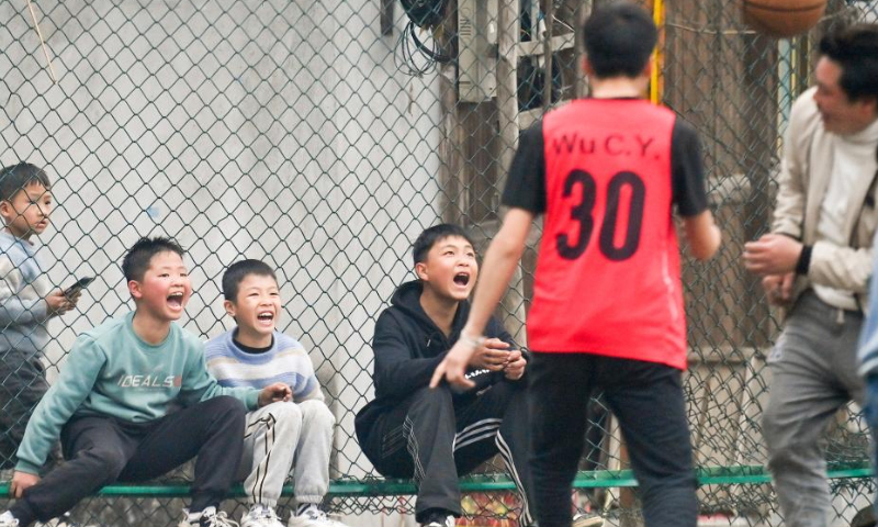 Kids watch a basketball match in Wuying village of Rongshui Miao Autonomous Prefecture, south China's Guangxi Zhuang Autonomous Region, Feb. 1, 2023. Basketball has long been popular in Wuying Village. In the past, the villagers played on a dirt court. The local government has been upgrading the infrastruture in recent years, including building a new basketball court of concrete. Now the sport becomes even more popular among the villagers, especially the kids. The village organizes basketball matches to celebrate festivals. (Xinhua/Huang Xiaobang)