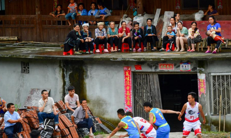 Villagers watch a basketball match held to celebrate the Xinhe Festival in Wuying village of Rongshui Miao Autonomous Prefecture, south China's Guangxi Zhuang Autonomous Region, July 19, 2019. Basketball has long been popular in Wuying Village. In the past, the villagers played on a dirt court. The local government has been upgrading the infrastruture in recent years, including building a new basketball court of concrete. Now the sport becomes even more popular among the villagers, especially the kids. The village organizes basketball matches to celebrate festivals. (Xinhua/Huang Xiaobang)