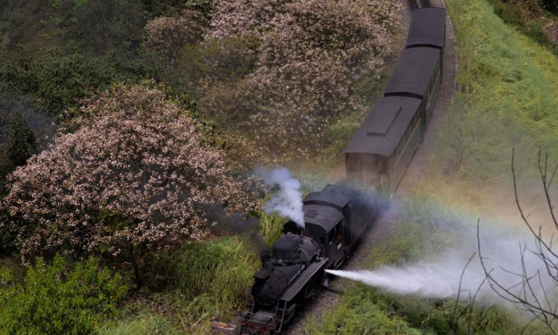 A rainbow appears in the water mist of a steam train passing by Liangshuituo station in Jianwei County, Leshan City, southwest China's Sichuan Province, April 9, 2023. (Xinhua/Jiang Hongjing)