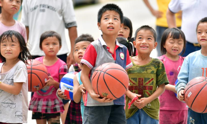 Kids play basketball in Wuying village of Rongshui Miao Autonomous Prefecture, south China's Guangxi Zhuang Autonomous Region, July 27, 2019. Basketball has long been popular in Wuying Village. In the past, the villagers played on a dirt court. The local government has been upgrading the infrastruture in recent years, including building a new basketball court of concrete. Now the sport becomes even more popular among the villagers, especially the kids. The village organizes basketball matches to celebrate festivals. (Xinhua/Huang Xiaobang)