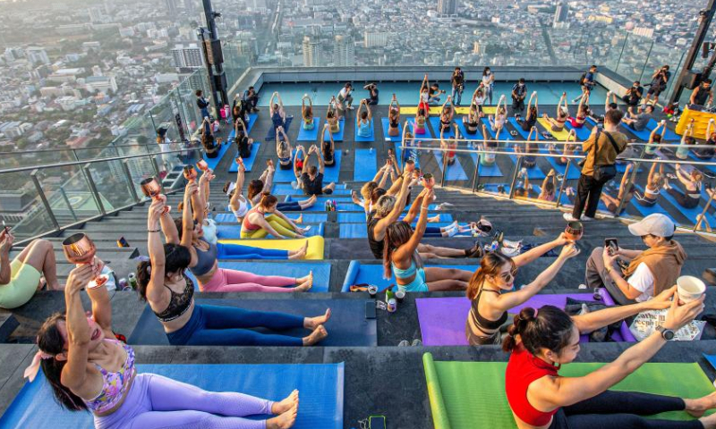 Yoga enthusiasts practice yoga at an observation deck on the rooftop of the King Power Mahanakhon building in Bangkok, Thailand, April 8, 2023. (Xinhua/Wang Teng)