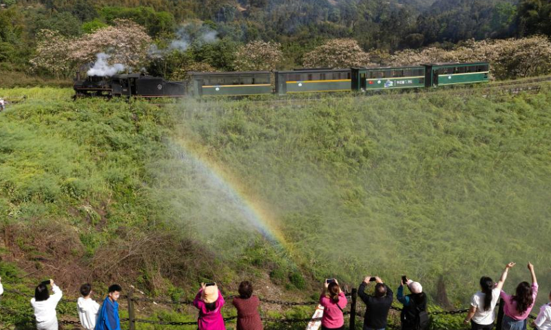 A rainbow appears in the water mist of a steam train passing by Liangshuituo station in Jianwei County, Leshan City, southwest China's Sichuan Province, April 9, 2023. (Xinhua/Jiang Hongjing)