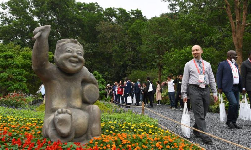 A guest looks at a statue at the Greater Bay Area Flower Show in Shenzhen, south China's Guangdong Province, April 8, 2023. The 10-day flower show was opened at Shenzhen Fairy Lake Botanical Garden on Saturday, attracting 80 exhibitors from 13 countries and regions including Australia, Britain, France, Japan, South Korea and the United States. (Xinhua/Liang Xu)