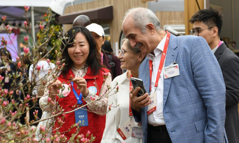 Guests enjoy flowers at the Greater Bay Area Flower Show in Shenzhen, south China's Guangdong Province, April 8, 2023. The 10-day flower show was opened at Shenzhen Fairy Lake Botanical Garden on Saturday, attracting 80 exhibitors from 13 countries and regions including Australia, Britain, France, Japan, South Korea and the United States. (Xinhua/Liang Xu)