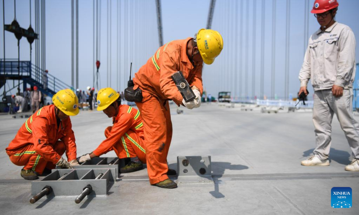 Workers assemble a box girder at the construction site of Lingdingyang bridge, which is part of the Shenzhen-Zhongshan link in south China's Guangdong Province, April 28, 2023. Lingdingyang bridge, a key part of the Shenzhen-Zhongshan link, got its final segments joined on Friday. Photo:Xinhua